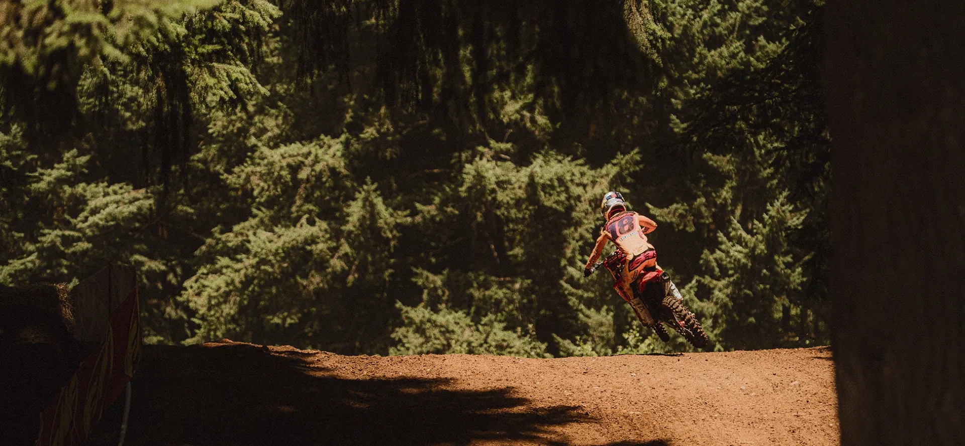 A man riding a dirtbike inside the jungle.
